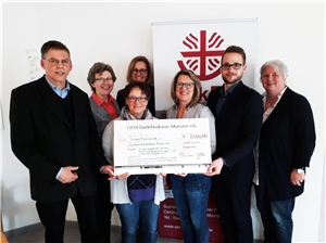 029-2019 Projekt Pflegefamilien Das Foto zeigt eine Gruppe von Menschen mit einem großen Scheck.