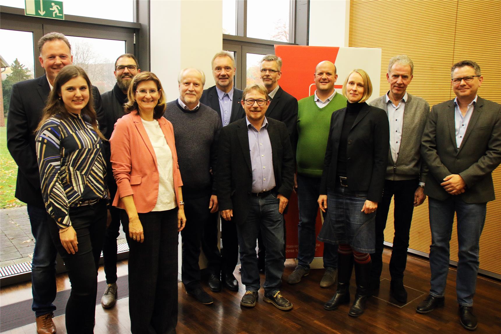 Eine Gruppe von 12 Personen schaut lächelnd in die Kamera.