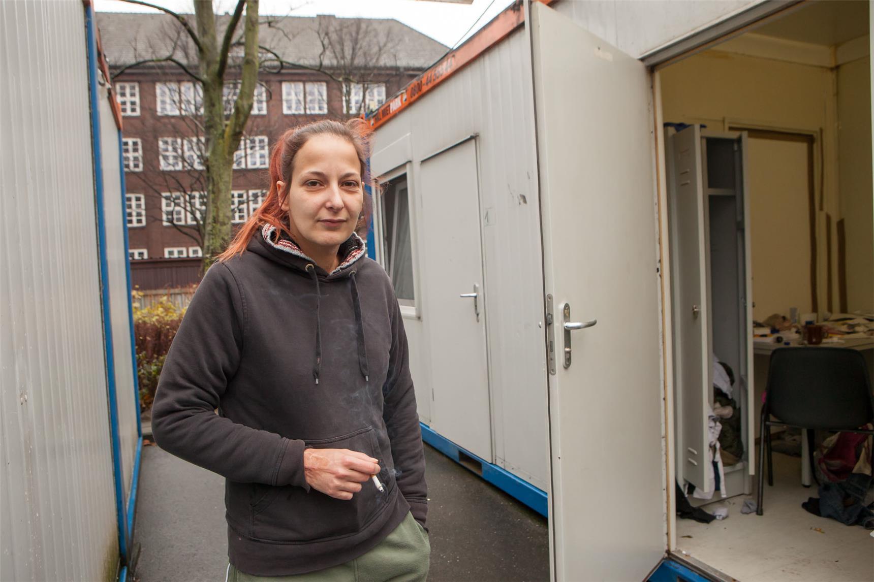 Eine Frau steht zwischen zwei Containern.