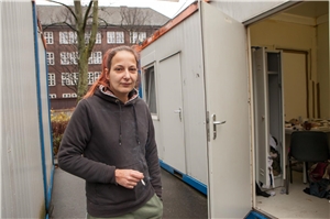 091-2020_Wählen_für_Wohnraum Eine Frau steht zwischen zwei Containern.