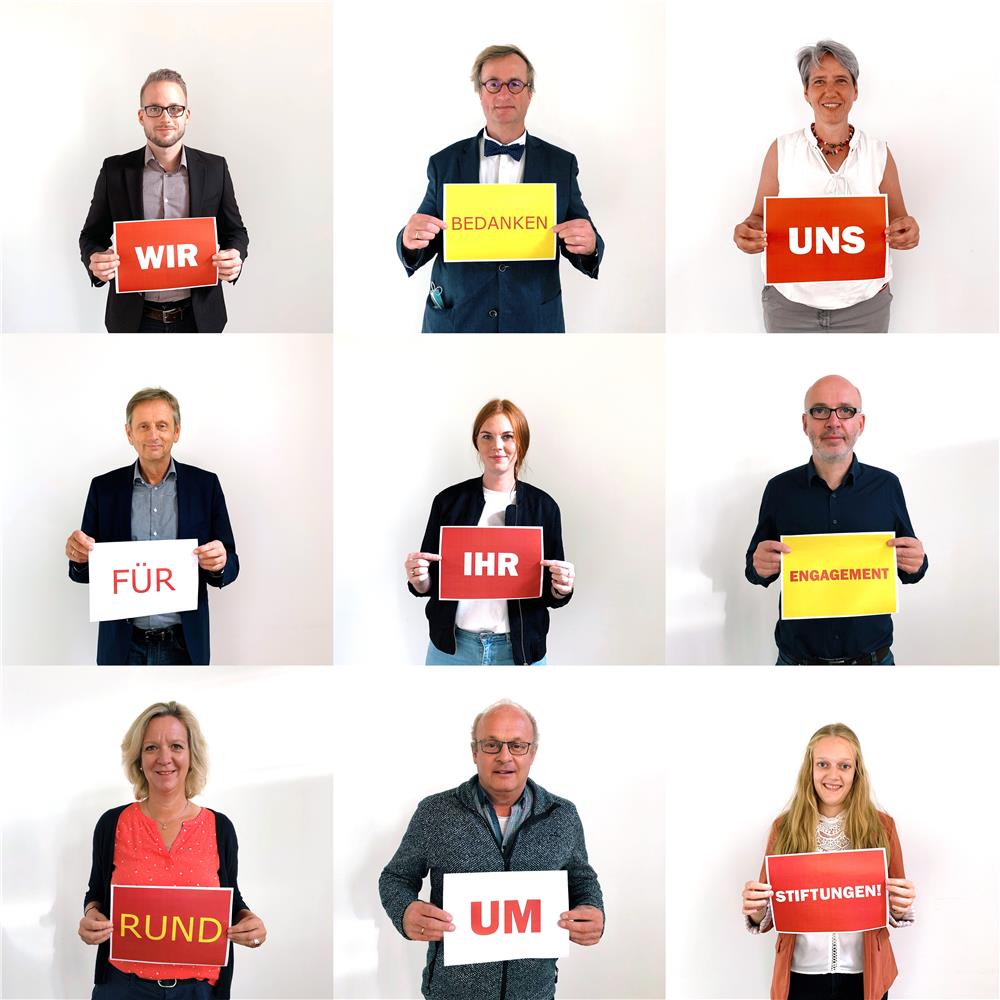 Neun Personen halten Plakate mit jeweils einem Wort fest, welche zusammen den Satz 