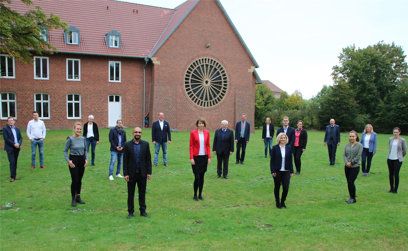 Das Foto zeigt eine große Gruppe Menschen, die sich mit corona-konformen Abstand in einem Innenhof aufgestellt haben.