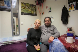 016-2022 Existenzminimumm Das Foto zeigt ein ärmlich gekleidetes Paar, das in einem kärglich ausgestatteten Raum sitzt.