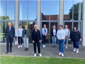 048-2022_Trainee_Kamingespräch Auf dem Bild sehen Sie neun Personen, die im Innenhof des Caritasverbandes der Diözese Münster sehen.