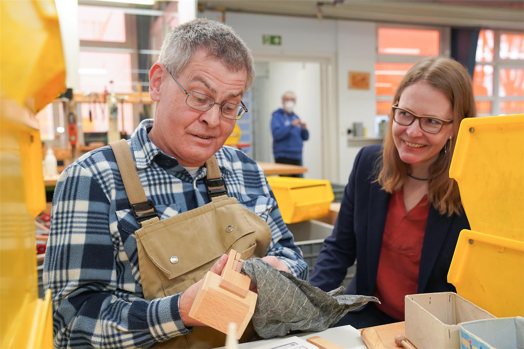 Ein Mitarbeiter der Caritas-Werkstatt in Borken entfernt den überschüssigen Leim eines Holzbaggers.