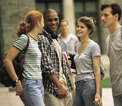 Zwei weibliche und zwei männliche Studenten stehen zusammen und lachen miteinander