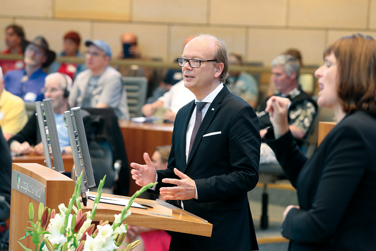 André Kuper, der vor dem Rednerpult im Plenarsaal des NRW-Landtags steht und eine Rede auf der Veranstaltung 'Zuhören – Anerkennen – Nicht vergessen! am 19.06.2019 hält
