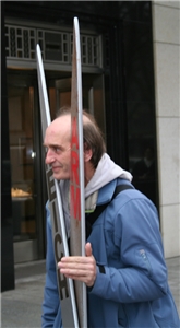 Aktion Schere zwischen Arm und Reich Ein Mann während einer Aktion von Caritas/Nationalen Armutskonferenz auf der Königsallee in D'dorf. Er hält seinen Kopf zwischen eine riesige Holzschere mit der Beschriftung Arm und Reich.