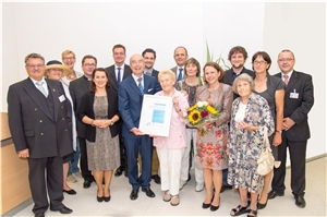 Caritasdirektor Dr. Roland Batz (4.v.l.), Krankenhaus-Geschäftsführer Dr. Joachim Ramming (6.v.l.), Professor Dr. Michael Nerlich (7.v.l.), Oberarzt Dr. Rainer Kretschmer (rechts), Leitende Geriaterin Dr. Ildiko Grell (5.v.l.), Dr. Uli Schmucker von der Deutschen Gesellschaft für Unfallchirurgie (8.v.l.) freuen sich zusammen mit Vertretern der Stadt, angeführt von Bürgermeisterin Gertrud Maltz-Schwarzfischer (5.v.r.) und Patienten und Mitarbeitern der Station über die Zertifizierung. (Foto: Krankenhaus St. Josef) AltersTraum Zertifikat ganz