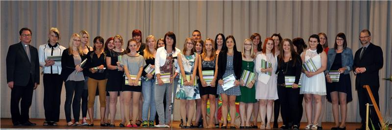 Caritasdirektor Dr. Roland Batz (links) und Schulleiter Karlheinz Binner mit den Absolventinnen des Berufspraktikums.
