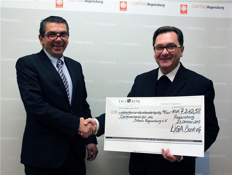 Filialdirektor Michael Pickl (links) übergibt Diözesan-Caritasdirektor Dr. Roland Batz (rechts) die Erträge aus der Caritas Credit Card als Spende.