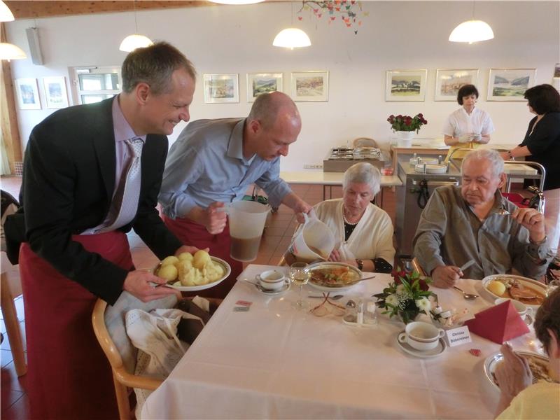 Oberbürgermeister Joachim Wolbergs und Caritas-Abteilungsleiter Robert Seitz servieren Heimbewohnern das Mittagessen.