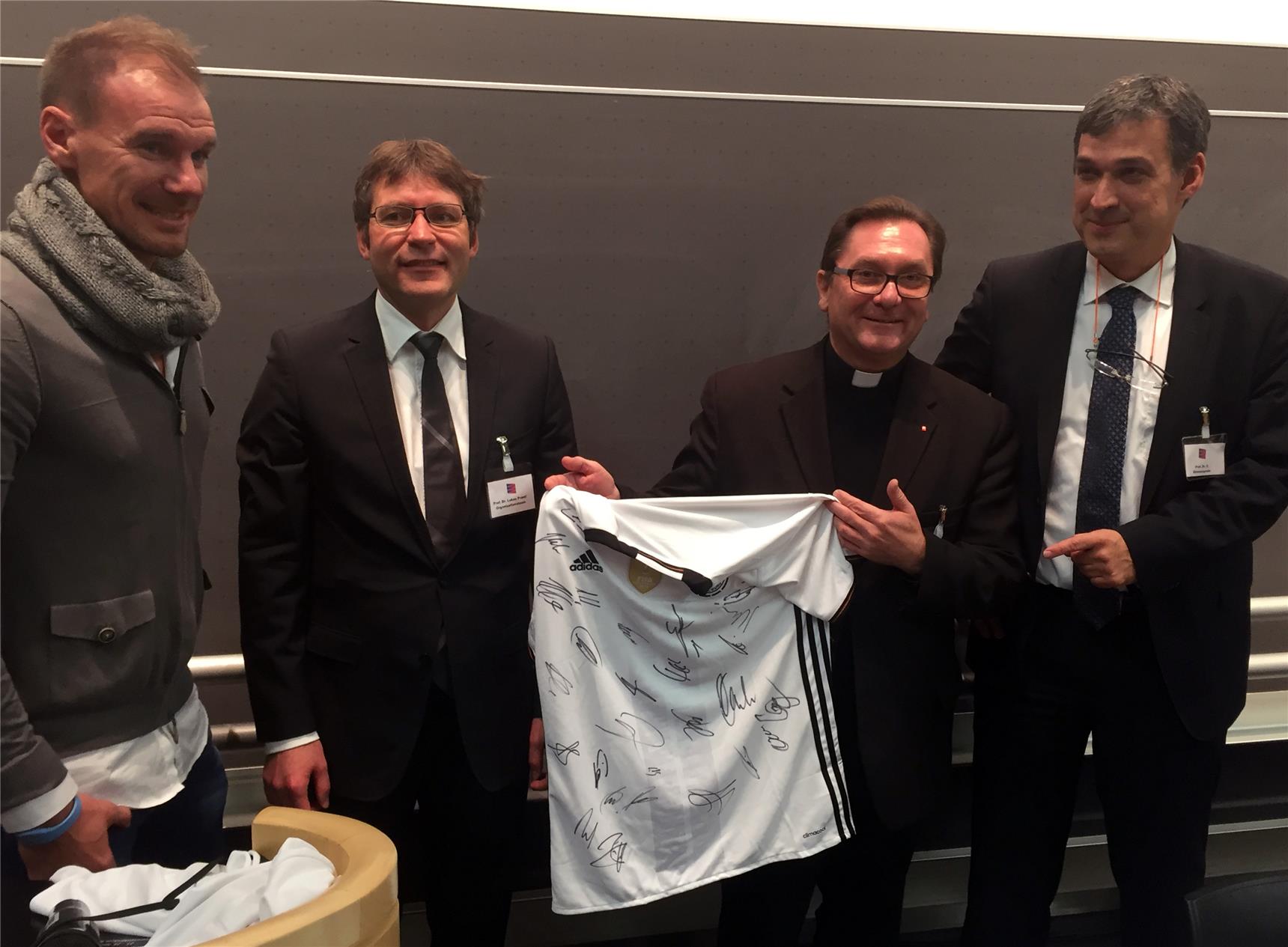 Das WM-Trikot mit allen Unterschriften der Weltmeister brachte allein 1300 Euro. Professor Dr. Christian Stroszczynski, Direktor des Instituts für Röntgendiagnostik am UKR, (rechts) leitete die Versteigerung. Mit im Bild: Ex-Fußballprofi Alexander Zickler (links), Professor Dr. Lukas Prantl (2.v.l.) und Diözesan-Caritasdirektor Dr. Roland Batz (2.v.r.).