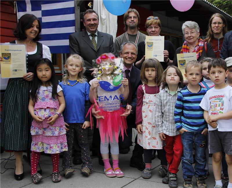 Sie präsentieren stolz Zertifikat und Urkunde: Die Leiterinnen der Caritas-Kindertageseinrichtungen und Kindergartenkinder mit Werner Beck (2.v.l.), Dr. Robert Seitz (3.v.l., knieend), Thomas Brunnhub