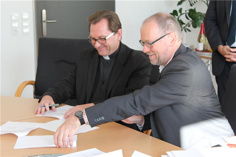 Caritasdirektor Dr. Roland Batz (links) und Hochschulpräsident Professor Peter Sperber (rechts) unterzeichnen den Kooperationsvertrag.