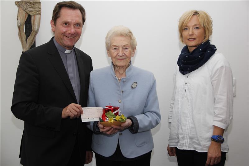 Diözesan-Caritasdirektor Dr. Roland Batz und Brigitte Weißmann, Chef-Organisatorin des Sonnenzuges, freuen sich über die liebevoll verpackte Spende von Hildegard Anke (Mitte).
