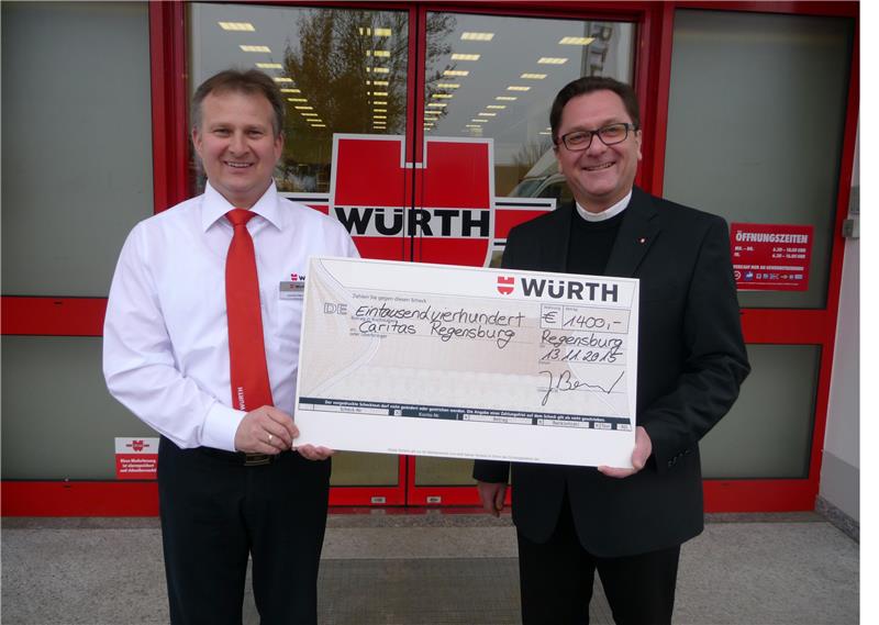 Niederlassungsspezialist Joachim Berner (links) und Diözesan-Caritasdirektor Dr. Roland Batz (rechts) bei der Spendenübergabe für die Flüchtlingsarbeit der Caritas Regensburg.