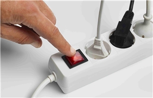 Stromabschaltung Hand an Stromleiste