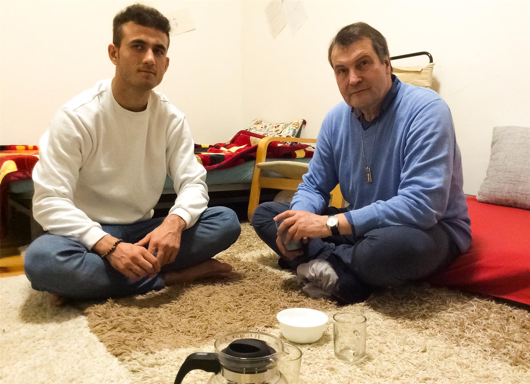 Ein Junge und ein Mann sitzen auf einem Teppich