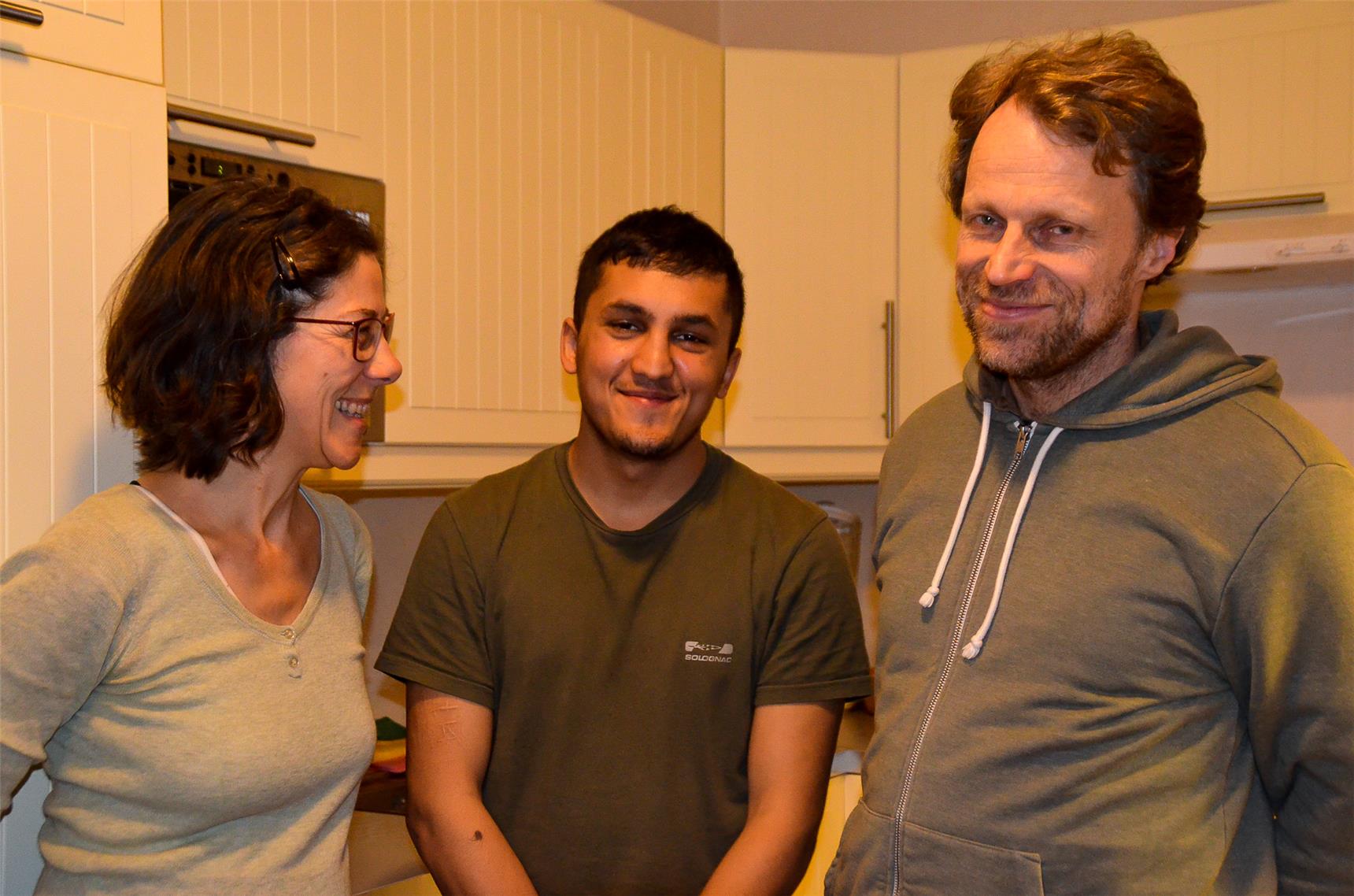 Eine Frau, ein Junge und ein Mann lächeln in die Kamera