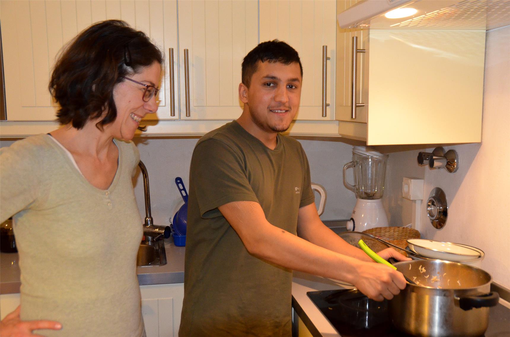 Ein Junge steht am Herd und kocht