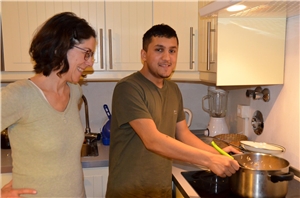 Berlin_Milad_mit Angelika beim Kochen Ein Junge steht am Herd und kocht