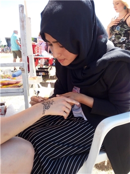 Dormagen_Masooda Henna Eine junge Frau mit Kopftuch bemalt eine Hand.