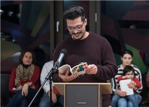 Fürth_Yasser_Der Brueckenbauer Ein junger Mann steht an einem Pult