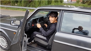 Hamburg_Ramazaan Verkehrsübungsplatz Ein Junge sitz in einem Auto mit geöffneter Fahrertür.