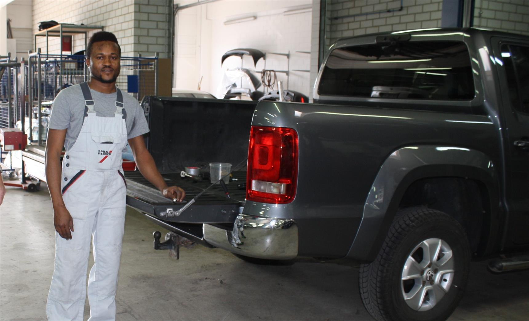 Junger Mann  in einer Autowerkstatt.