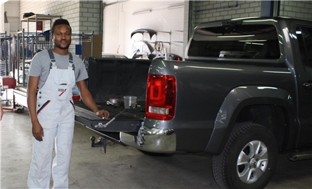 Hebertshausen_Sunday Albert O_geschnitten Junger Mann  in einer Autowerkstatt.