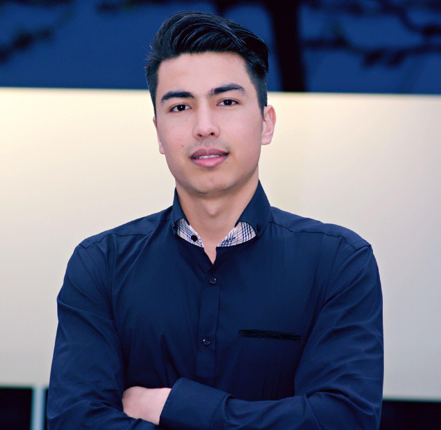 Ein junger Mann im Hemd schaut in die Kamera.