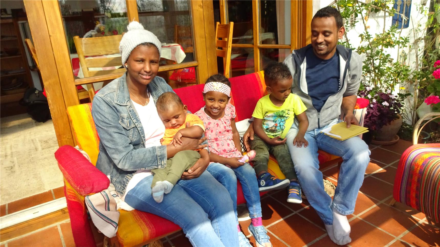 Eine Familie mit drei Kindern auf einer Hollywood-Schaukel.