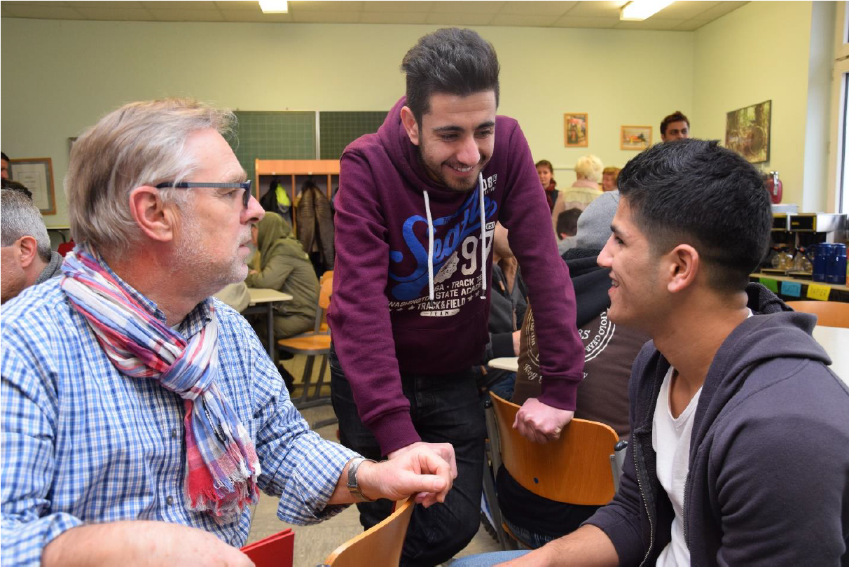 Ein Mann ist mit zwei Jugendlichen im Gespräch