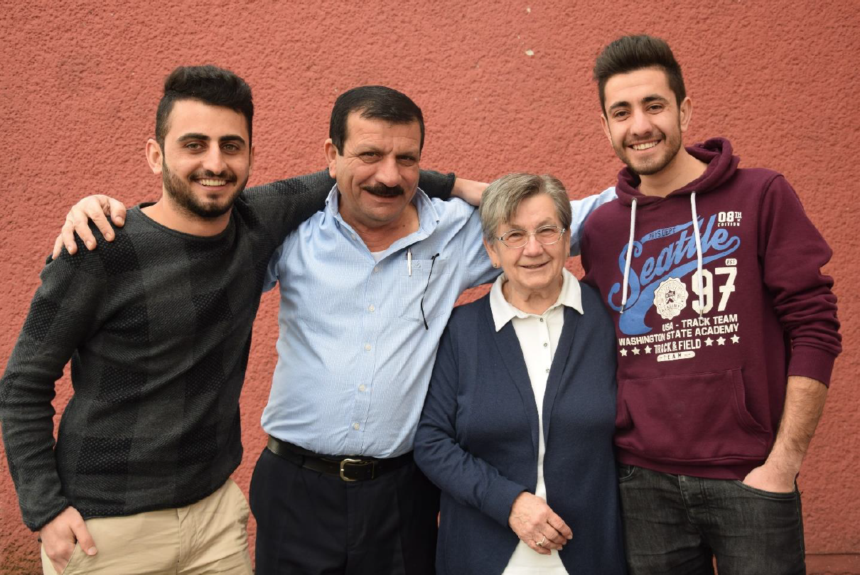 Reber, Barakat und Suleiman stehen mit Ellen vor einer Wand