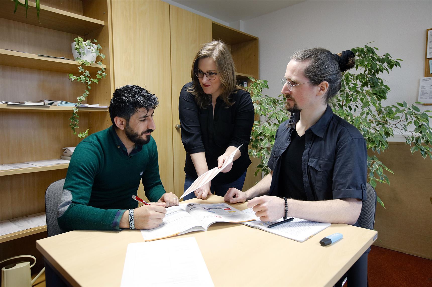 Geflüchteter im Gespräch mit Caritas-Mitarbeitenden