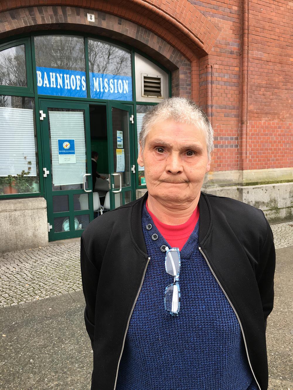 Frau vor Bahnhofsmission stehend