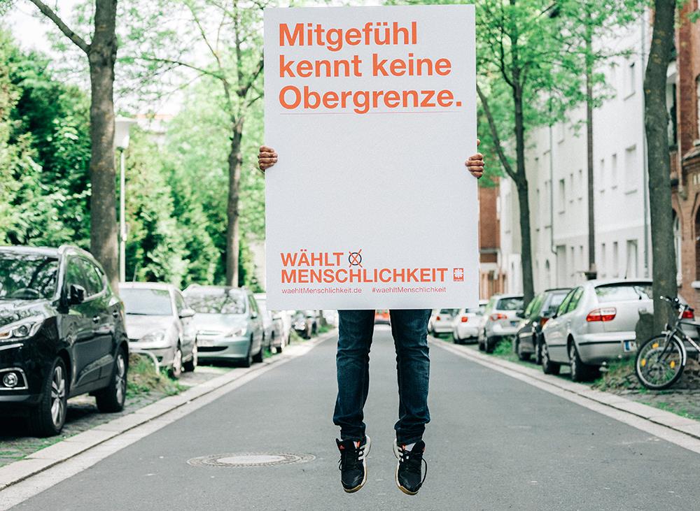 Mann mit Aktionsschild vor dem Kopf