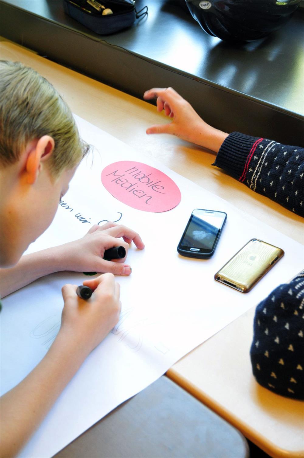 Schüler mit Smartphones im Unterricht