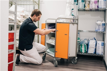 008 - SozialBrauchtDigital_web (19 von 23) Mann kniet in Krankenhaus vor Wagen mit Bettlaken darin