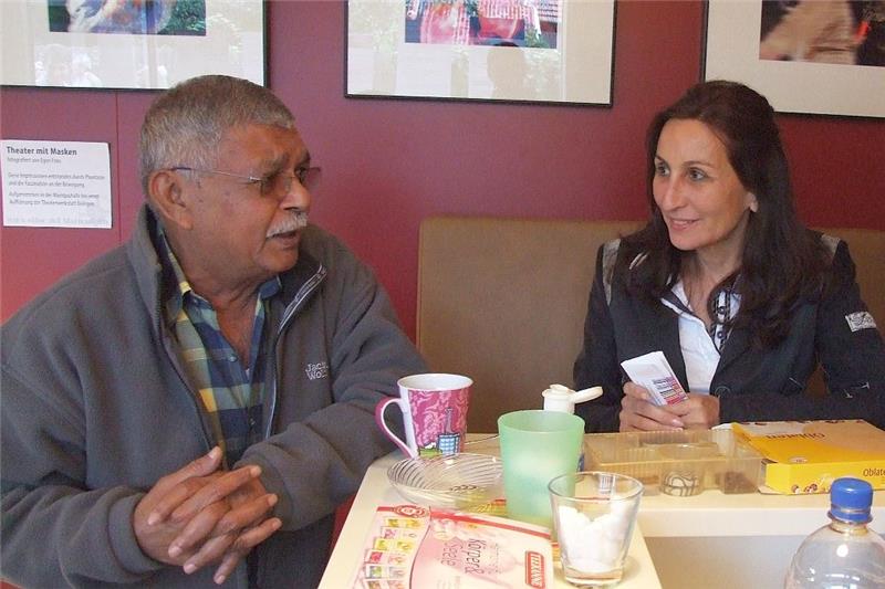 Zwei Gäste des Café international unterhalten sich am Kaffeetisch.