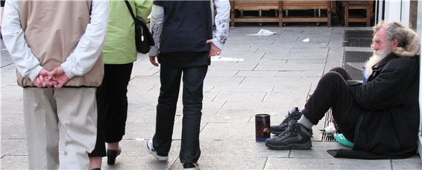 Mann sitzt bettelnd am Straßenrand Mann sitzt bettelnd am Straßenrand