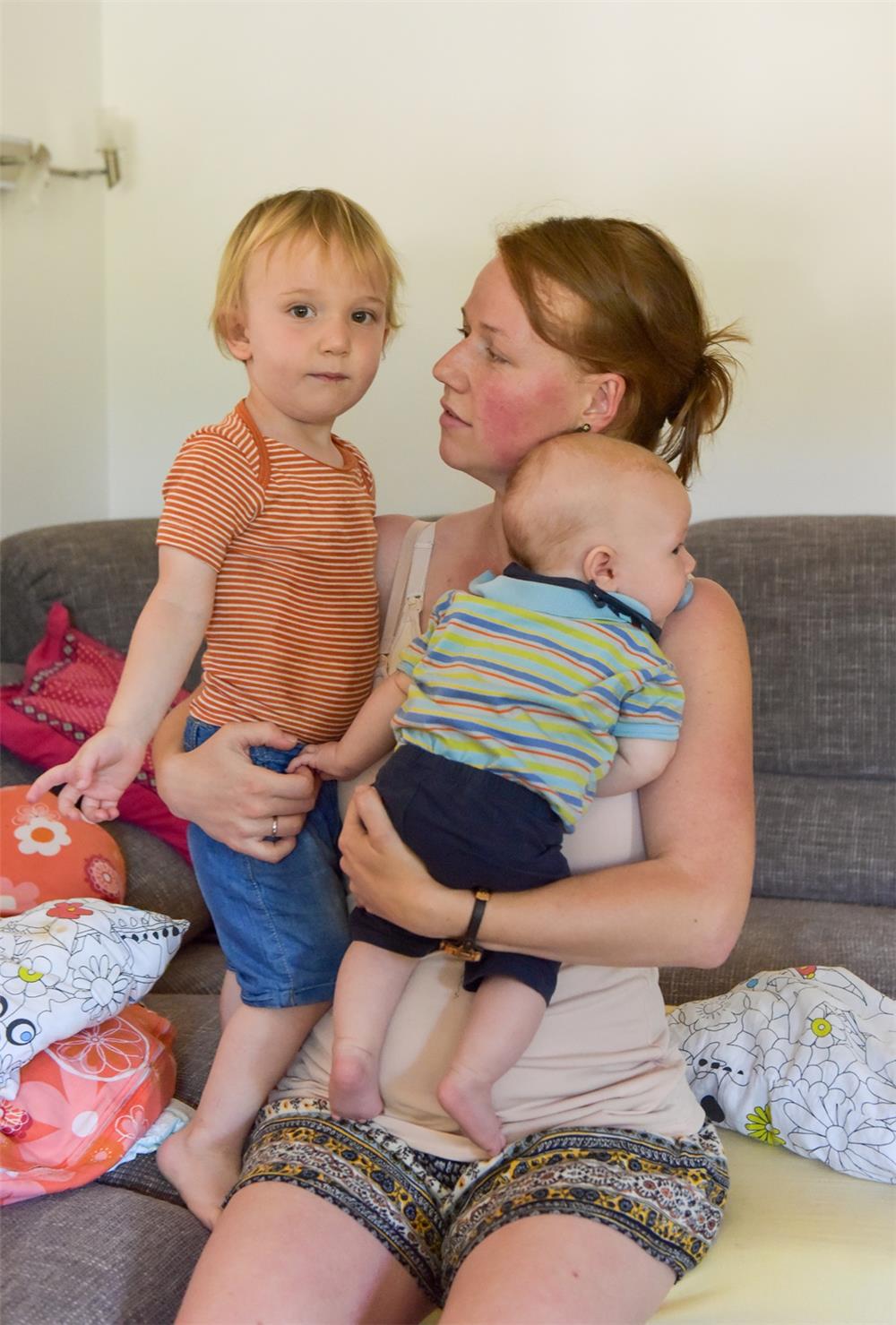 Eine Mutter mit zwei kleinen Kindern im Arm