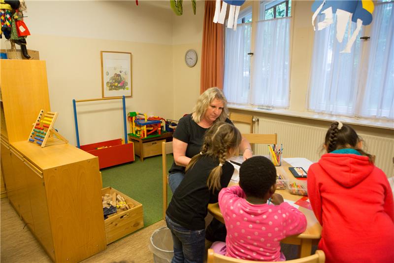 Eine Erzieherin malt mit den Kindern