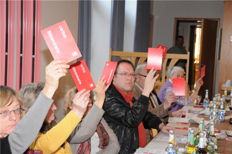 Delegierte heben Stimmzettel bei Abstimmung