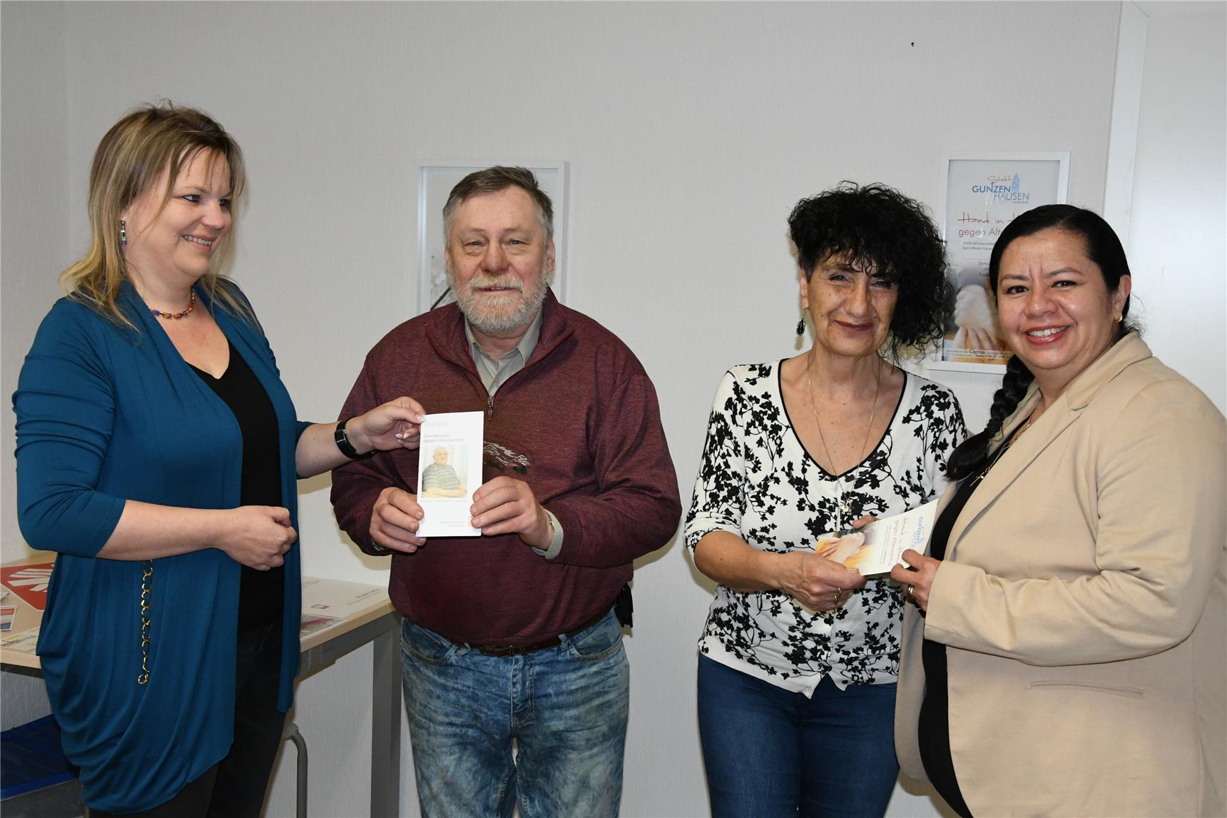 Drei Frauen und ein Mann stehen zusammen