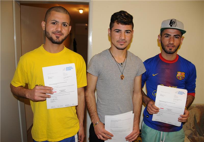 Drei Männer mit positiven Bescheiden in den Händen