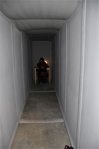 langer dunkler Gang mit Schreibtisch am Ende