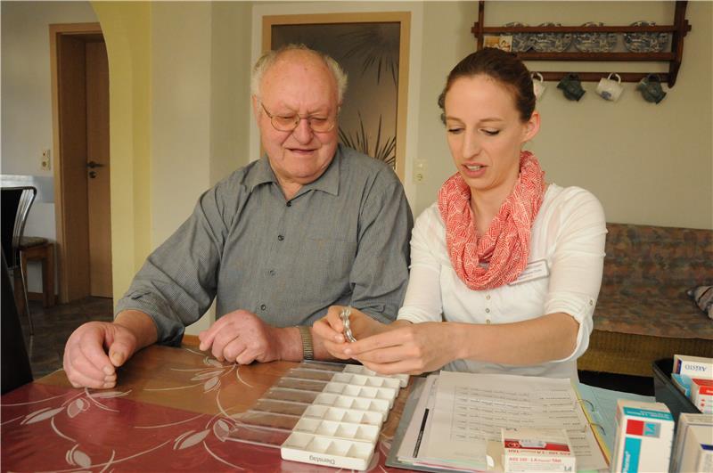 Schwester Doris bereitet altem Mann Medikamente vor