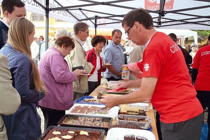 Kuchenausgabe am Stand der Caritas